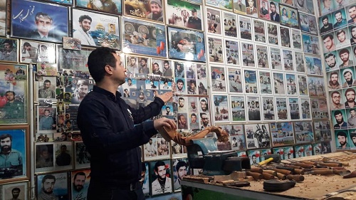 نمایشگاه 20 متری از عکس شهدا در مغازه جوان ملایری
